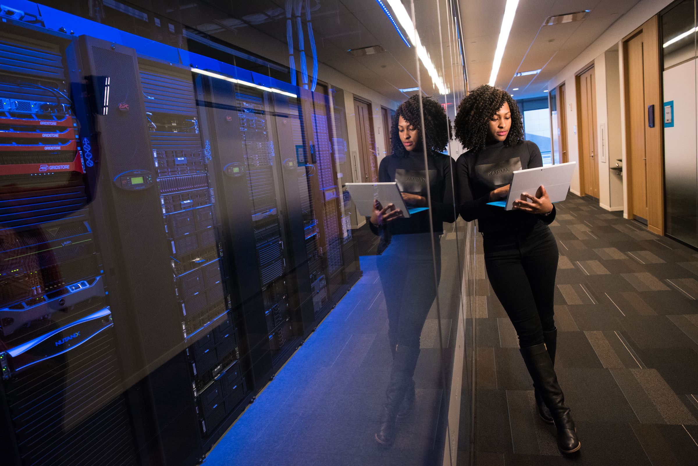 Engineers with tablets in a data centre aisle